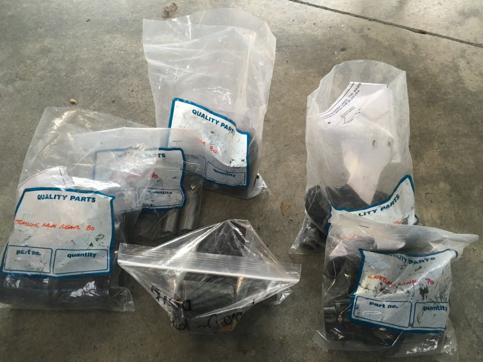 Automotive parts in plastic bags on concrete floor.