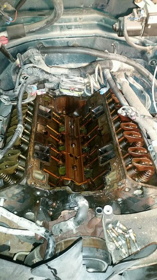 1999 Chevrolet Suburban engine bay with valve covers removed, showing internal components.