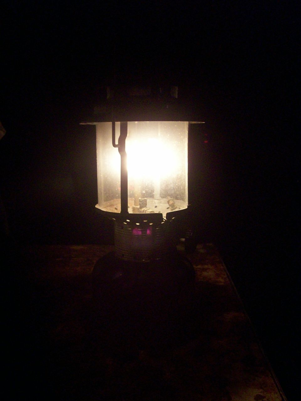 A lit kerosene lantern in the dark.