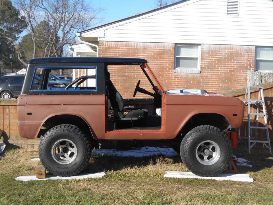 Brown 1972 Ford Bronco with doors removed, parked in a yard.