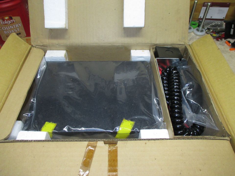 Photo of an open box with a CB radio and coiled mic cord
