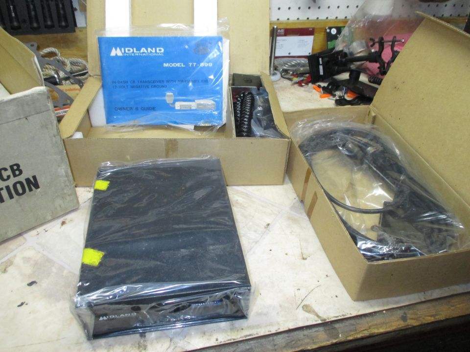 Photo of CB radio parts and owner's guide on a bench