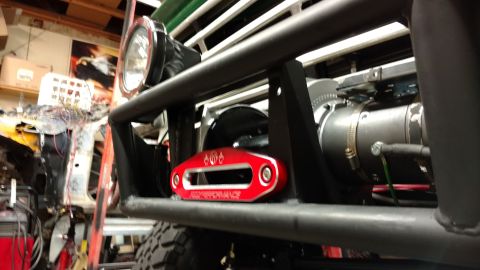 1967 Ford F-250 - Close-up of a winch fairlead on a modified truck's front bumper.