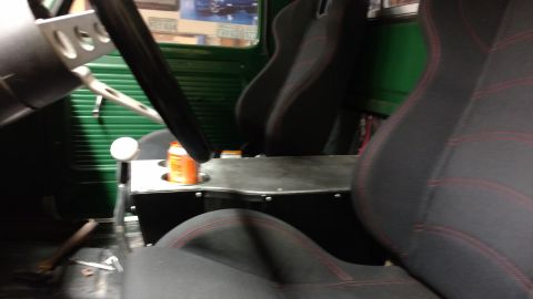 1967 Ford F-250 - The interior of a truck features aftermarket racing seats and a custom console with a drink holder.