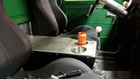 1967 Ford F-250 - Interior view of a green truck, showing custom seats and a center console with a soda can.