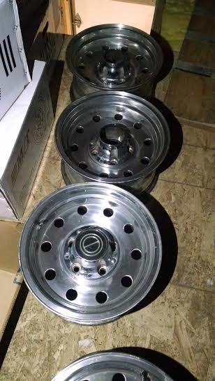 1994 Ford Bronco - Three aluminum wheels are stacked and visible from the front, with a Ford logo on the center cap.