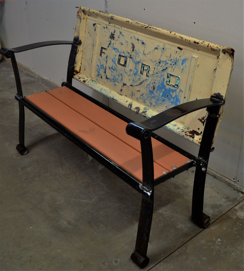 Bench with a distressed yellow Ford tailgate as the backrest