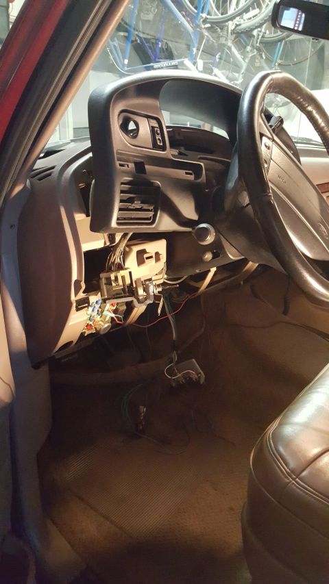 1996 Ford Bronco - The interior of a vehicle shows exposed wiring and components beneath the dashboard, with the steering wheel in view.