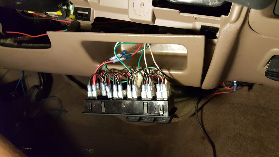 Aftermarket switch panel with wires connected to vehicle interior