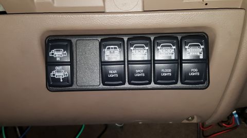 1996 Ford Bronco - This switch panel has icons depicting SUVs and controls for various lights and a winch.