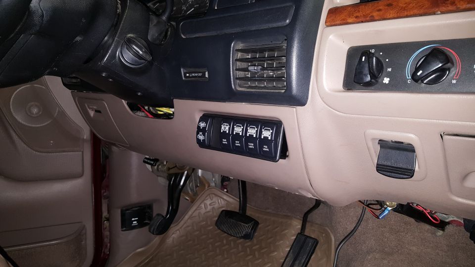 Aftermarket switch panel with icons for lights installed on dashboard