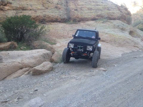 1987 Suzuki Samurai - This modified 1987 Suzuki Samurai navigates a , mountainous terrain with large boulders and sparse vegetation.