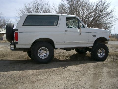 1994 Ford Bronco - Side view of a lifted 1994 Ford Bronco with a spare tire mounted externally on the rear.
