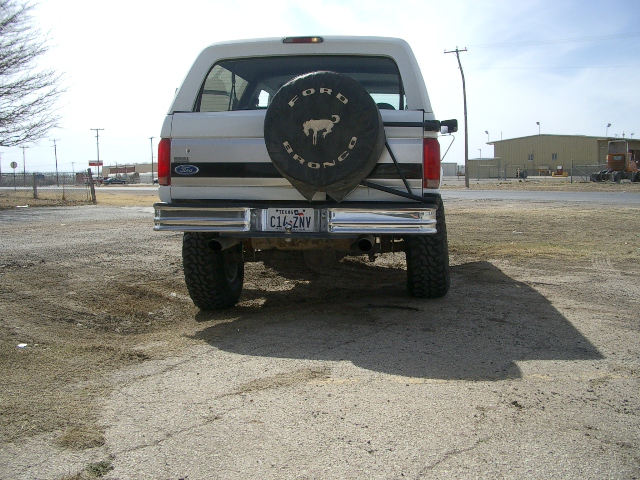 Rear view of a lifted Ford Bronco with a spare tire on the back. License plate reads C14-ZNV
