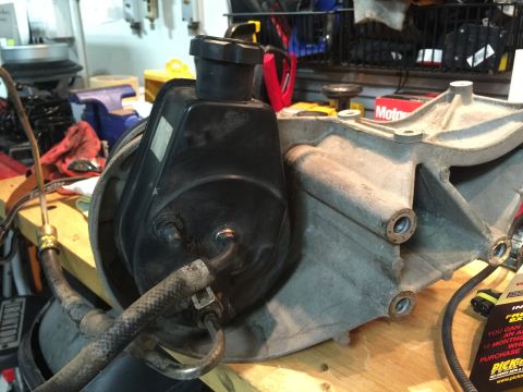 1996 Ford Bronco - Close-up of a power steering pump and its associated bracket, likely removed for repair or replacement.