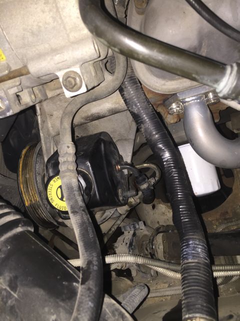 1996 Ford Bronco - Close-up of a vehicle's power steering pump and pulley assembly.