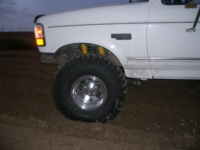 White 1994 Ford Bronco front fender and wheel with "BRONCO" badge visible