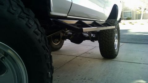 1979 Ford Bronco - Side view of a 1979 Ford Bronco with custom rock sliders and large off-road tires.