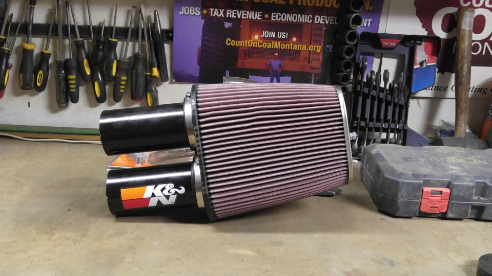 K&N air filter with dual black intake tubes, resting on a concrete surface