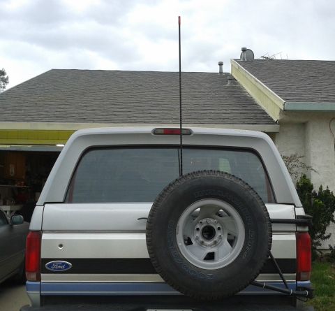 1996 Ford Bronco - The rear of a Ford Bronco shows a spare tire and a tall antenna, with a "Ford" badge visible on the side.