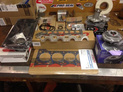1987 Suzuki Samurai - Various engine parts including gaskets, a water pump, and fan clutch are organized on a surface.