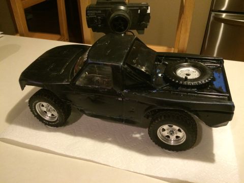 1989 Ford Bronco - This remote control truck is black with a spare tire mounted on the rear bed.