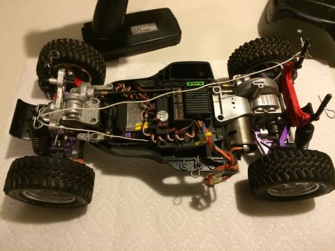 1989 Ford Bronco - The underside of a remote control car chassis reveals its internal mechanics, including the motor, servos, and suspension system.