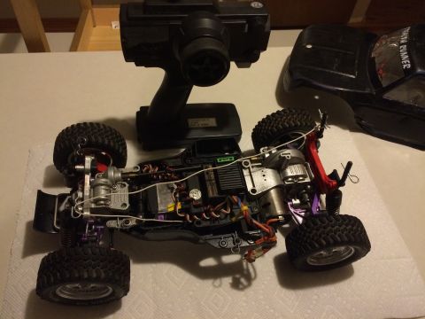 1989 Ford Bronco - A disassembled remote control car with its controller and body shell are laid out on a surface.