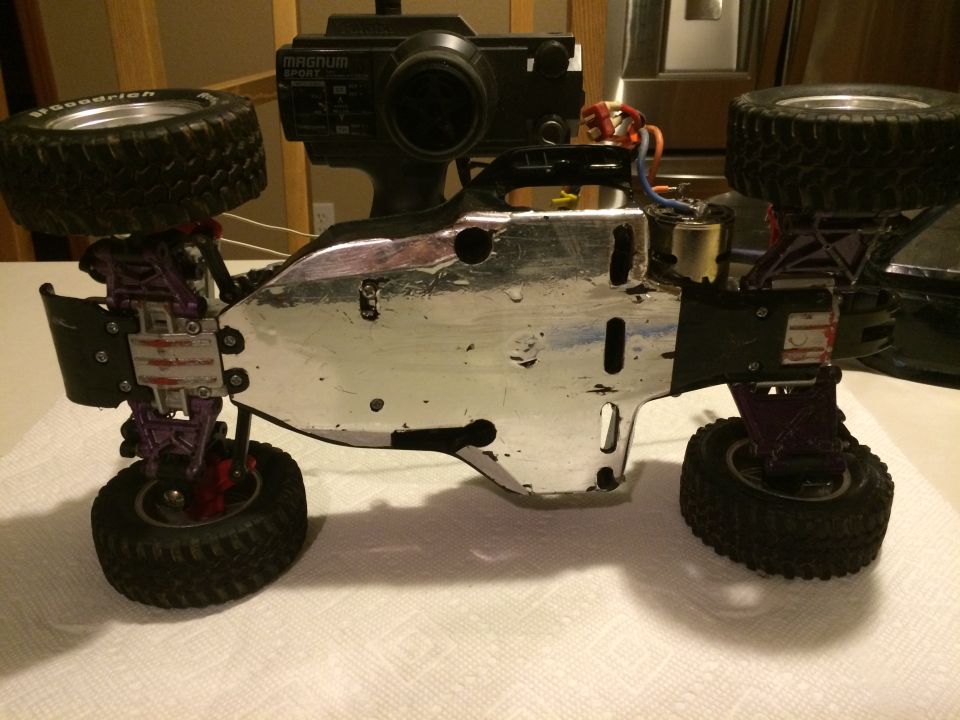 Radio-controlled car chassis with silver body, purple suspension, and BFGoodrich tires