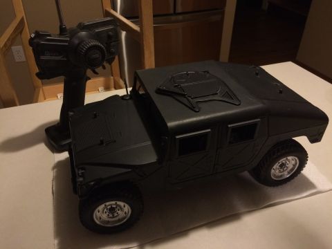 1989 Ford Bronco - A black remote control toy truck sits on a surface with its controller nearby.