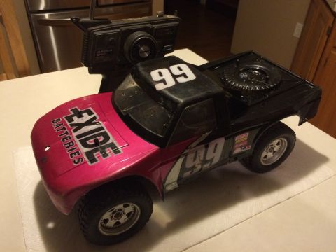 1989 Ford Bronco - Remote control toy truck with 'Exide Batteries' and '99' graphics, alongside its controller.