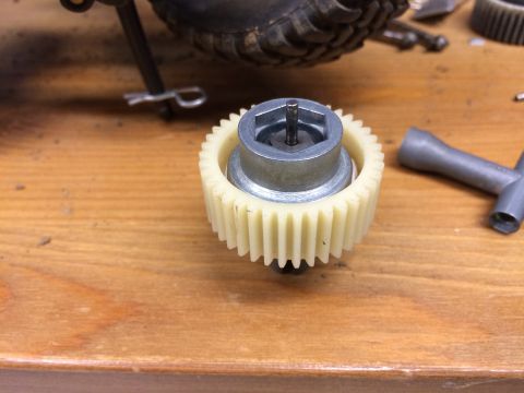 1989 Ford Bronco - A close-up shot shows a plastic gear with a metal hub and a small pin inserted into the top. A metal tool with multiple sockets is visible…