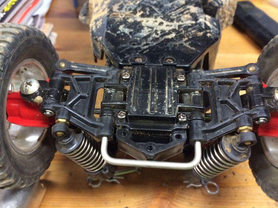 Rear suspension and wheel of a dirty RC car.