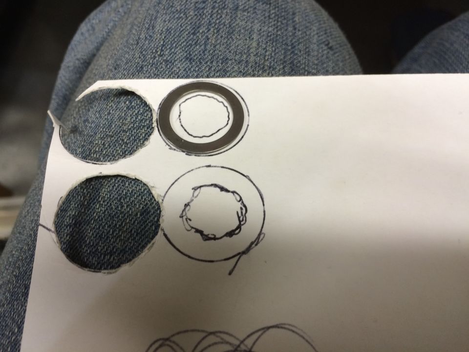 Paper with cut out circles on blue jeans