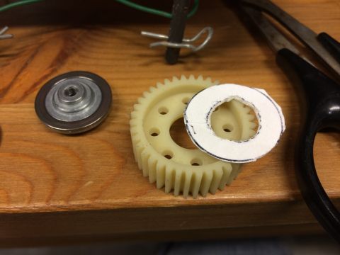 1989 Ford Bronco - A close-up shot shows a metal bearing and a plastic gear on a wooden surface. A piece of white paper with a circular cutout and black marki…