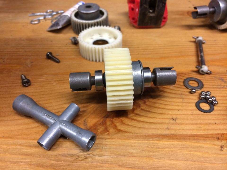 Gears, bearings, and tools on a wooden surface