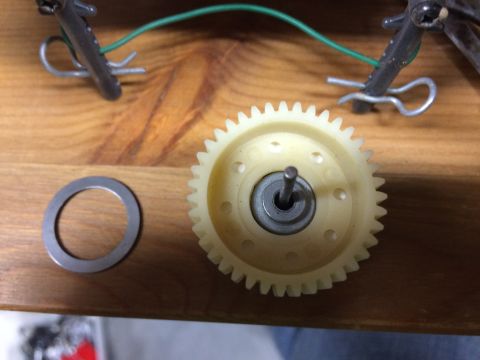 1989 Ford Bronco - A close-up view shows a plastic gear with a metal shaft and bearing, next to a metal washer. In the background, a green wire is attached to…