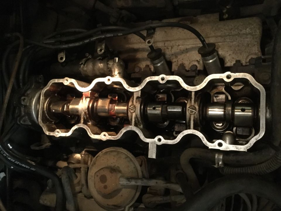 Close-up of a car engine's camshaft and valve train with the valve cover removed.