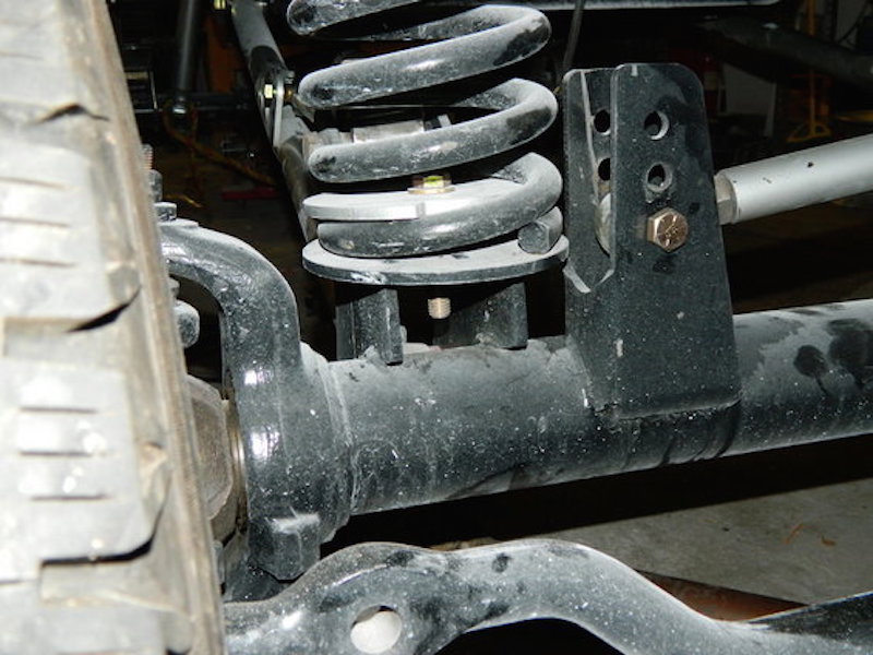 1981 Ford Bronco suspension close-up: coil spring, shock mount, axle.