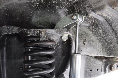 1981 Ford Bronco - A close-up view of the suspension system of a 1981 Ford Bronco, showing the coil spring and a modified shock absorber mount.