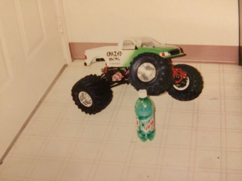 1989 Ford Bronco - A remote control monster truck with large tires and 'CRAZED RACING' written on the side sits on a tiled floor.
