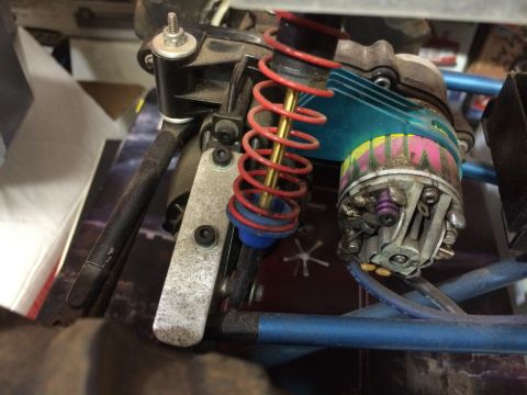 1989 Ford Bronco - Close-up view of the suspension and electric motor assembly of an RC car. The motor has a blue heatsink and a colorful decorative band, att…