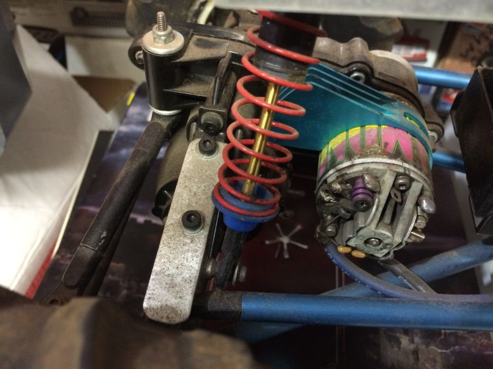 RC car electric motor with blue heatsink and red coil-over shock.