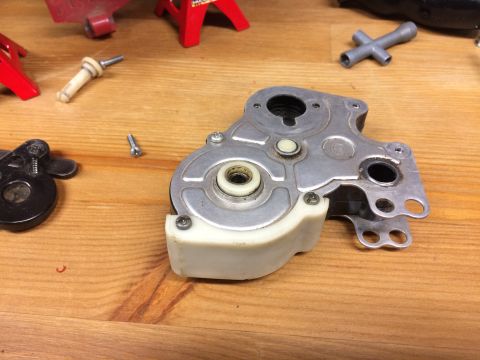 1989 Ford Bronco - A disassembled mechanical component with a white plastic housing is shown on a wooden surface. Various screws and other small parts are sca…
