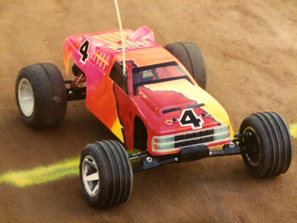 RC off-road truck with colorful body and number 4 on dirt track