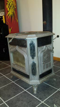 1978 Ford Bronco - A vintage cast iron wood stove with ornate detailing and a black stovepipe is shown in a room with a tiled floor. To the left, a portion of…