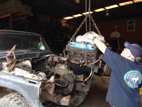 1979 Ford Bronco - A vehicle is hoisted onto a flatbed truck under the cover of darkness.