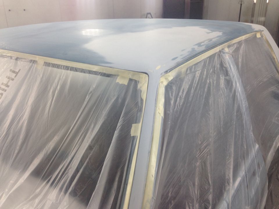 Car roof covered in plastic sheeting and masking tape, ready for paintwork