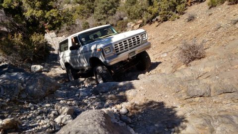 1979 Ford Bronco - A white 1978 Ford Bronco navigates a challenging rocky terrain on an off-road adventure.