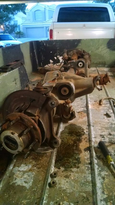 1979 Ford Bronco - Vehicle parts are shown in a truck bed, with a white SUV and a house visible in the background.